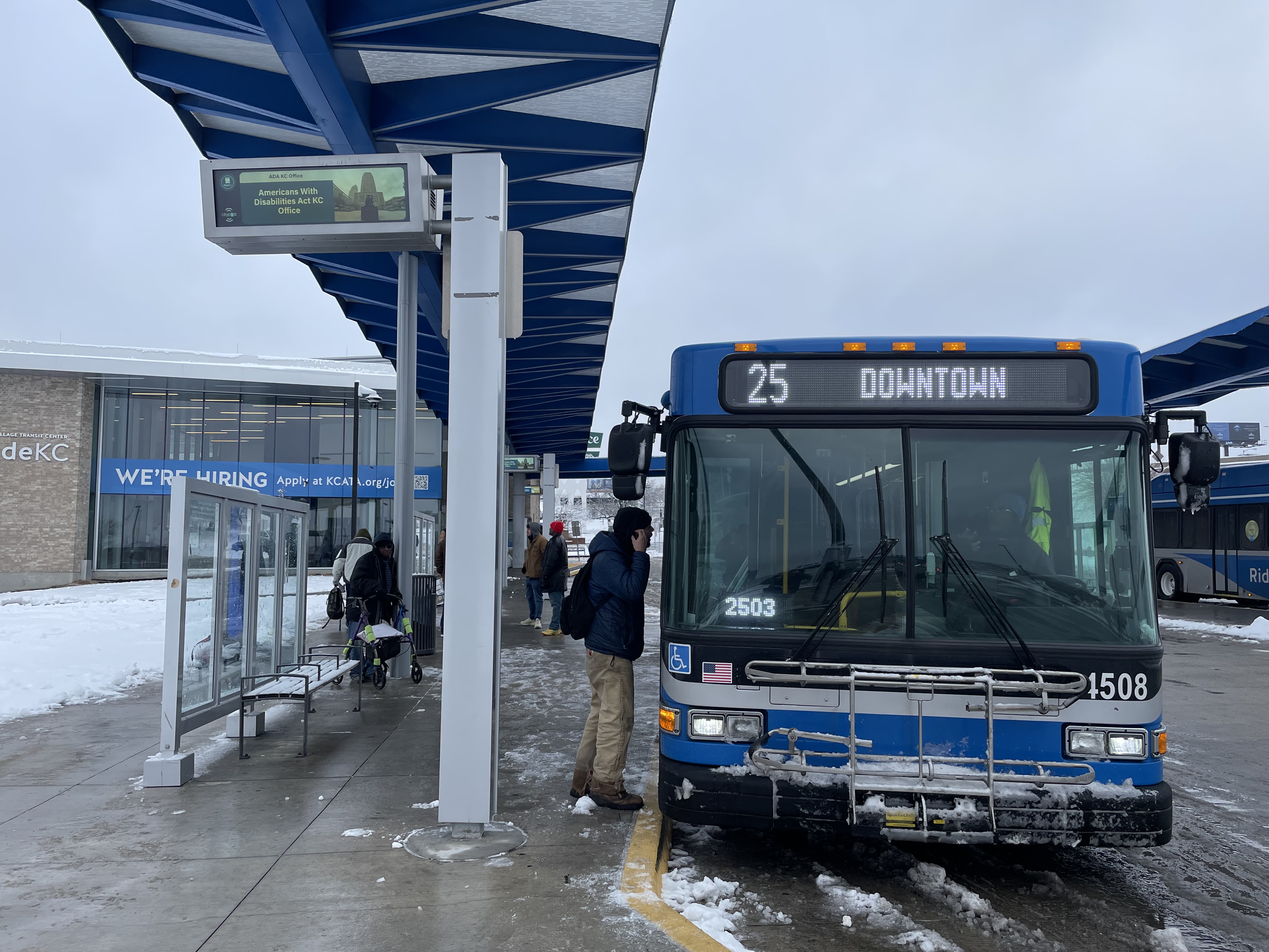 Rider boarding a bus on a snowy road